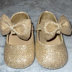Gold glitter shoes with bow.